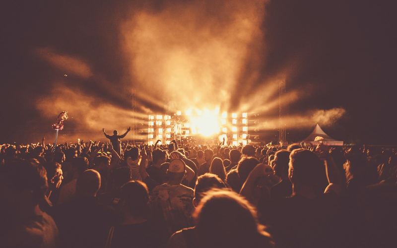 Concert crowd facing a lit festival stage